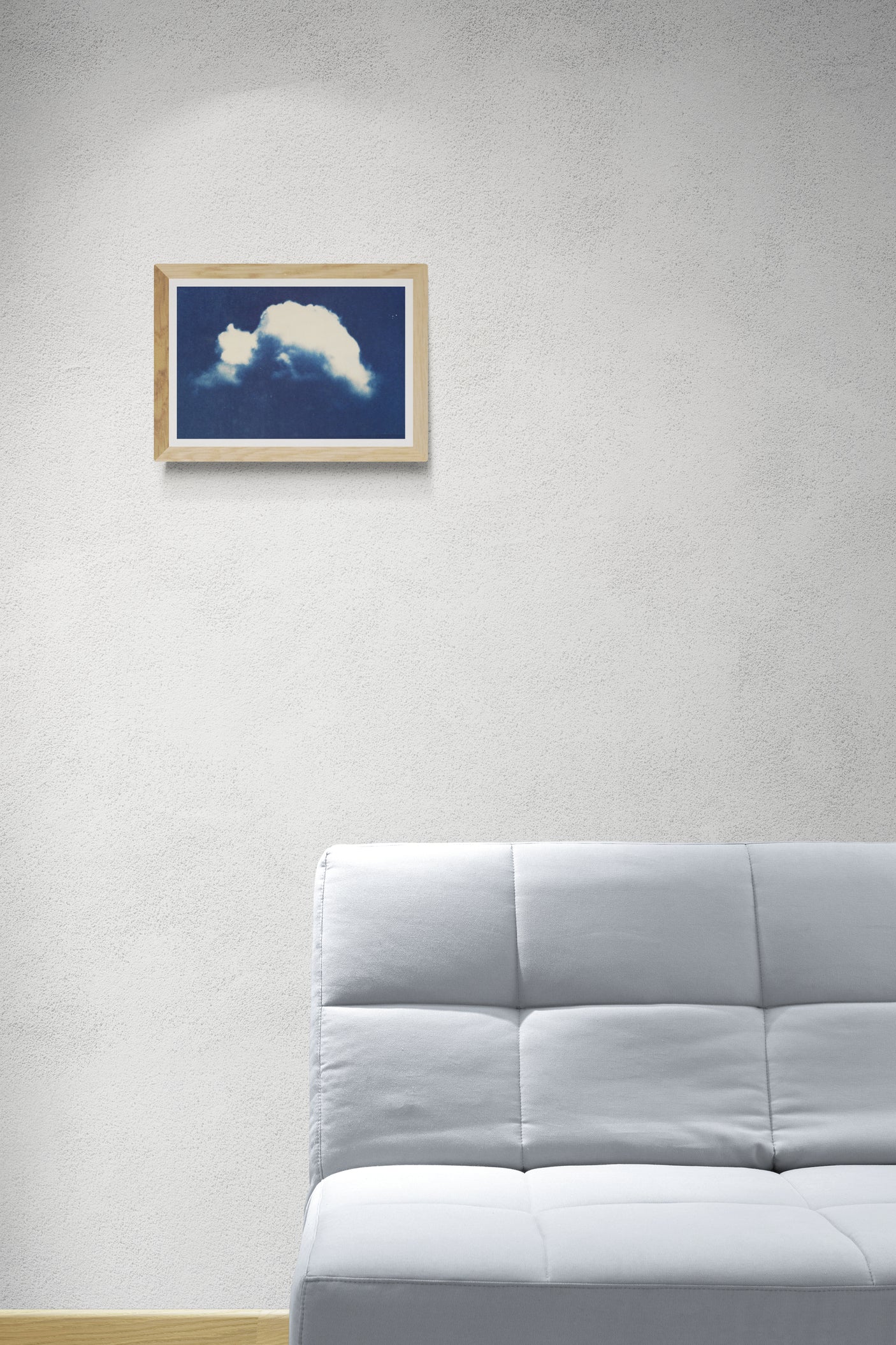 Œuvre encadrée de la collection Cyanotype en mise en situation représentant un nuage seul dans le ciel bleu.
