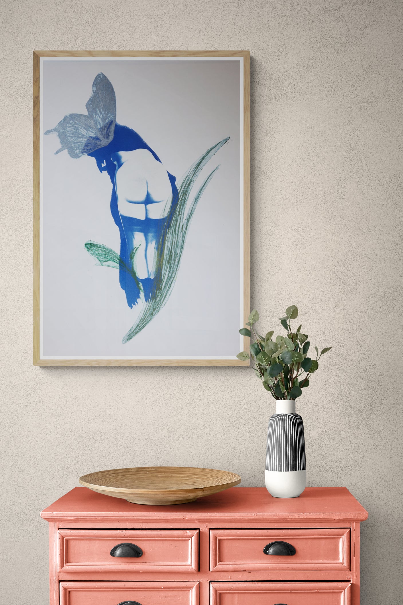 Œuvre de la collection Memoria encadrée, cyanotype et gravure sur papier, représentation d’un corps avec un papillon, teintes bleues et vertes, présentée en intérieur.
