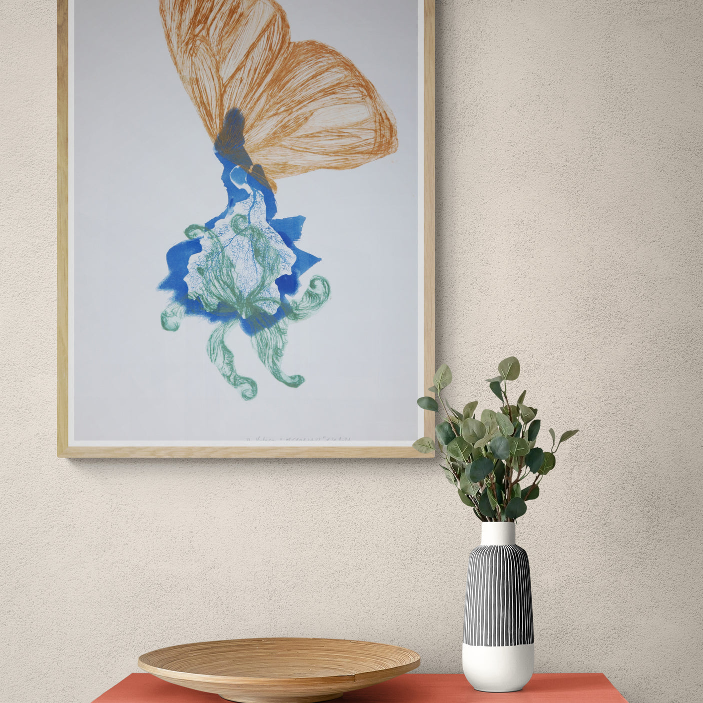 Œuvre de la collection Memoria encadrée, cyanotype et gravure sur papier, motif de papillon orange et de fleur, présentée en intérieur.