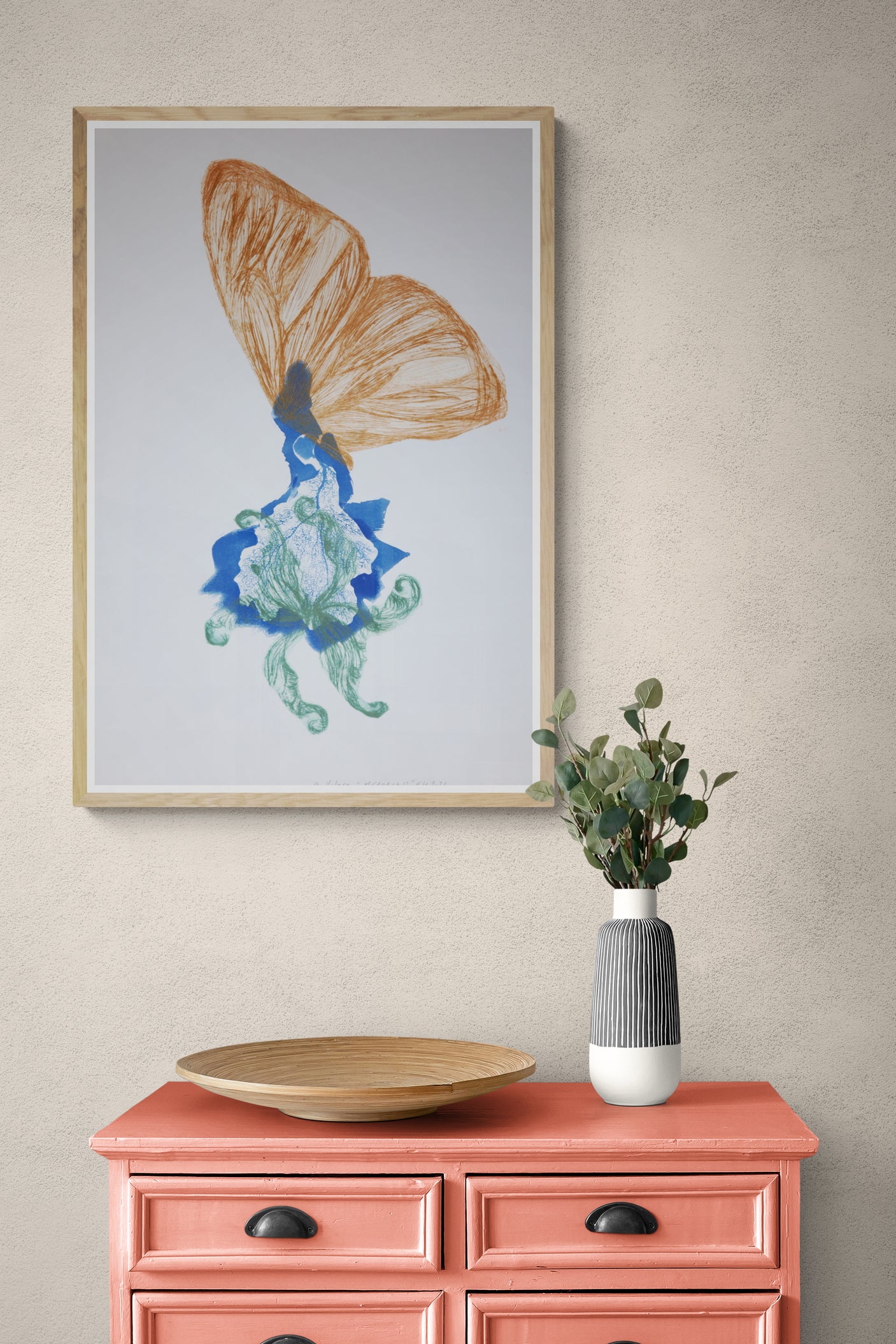 Œuvre de la collection Memoria encadrée, cyanotype et gravure sur papier, motif de papillon orange et de fleur, présentée en intérieur.