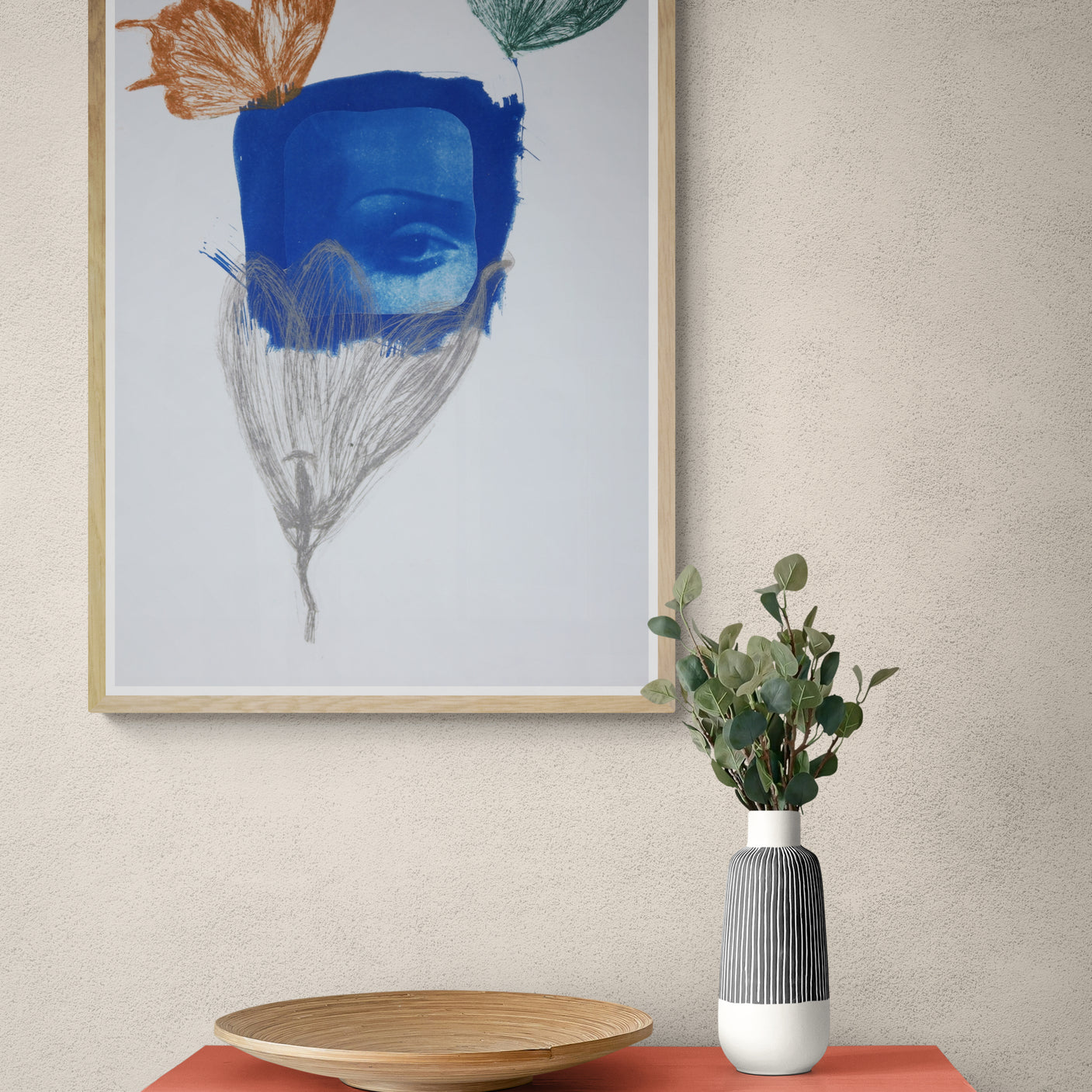 Œuvre de la collection Memoria encadrée, cyanotype et gravure sur papier, motif de papillons et d’un œil évoquant le regard, présentée en intérieur.