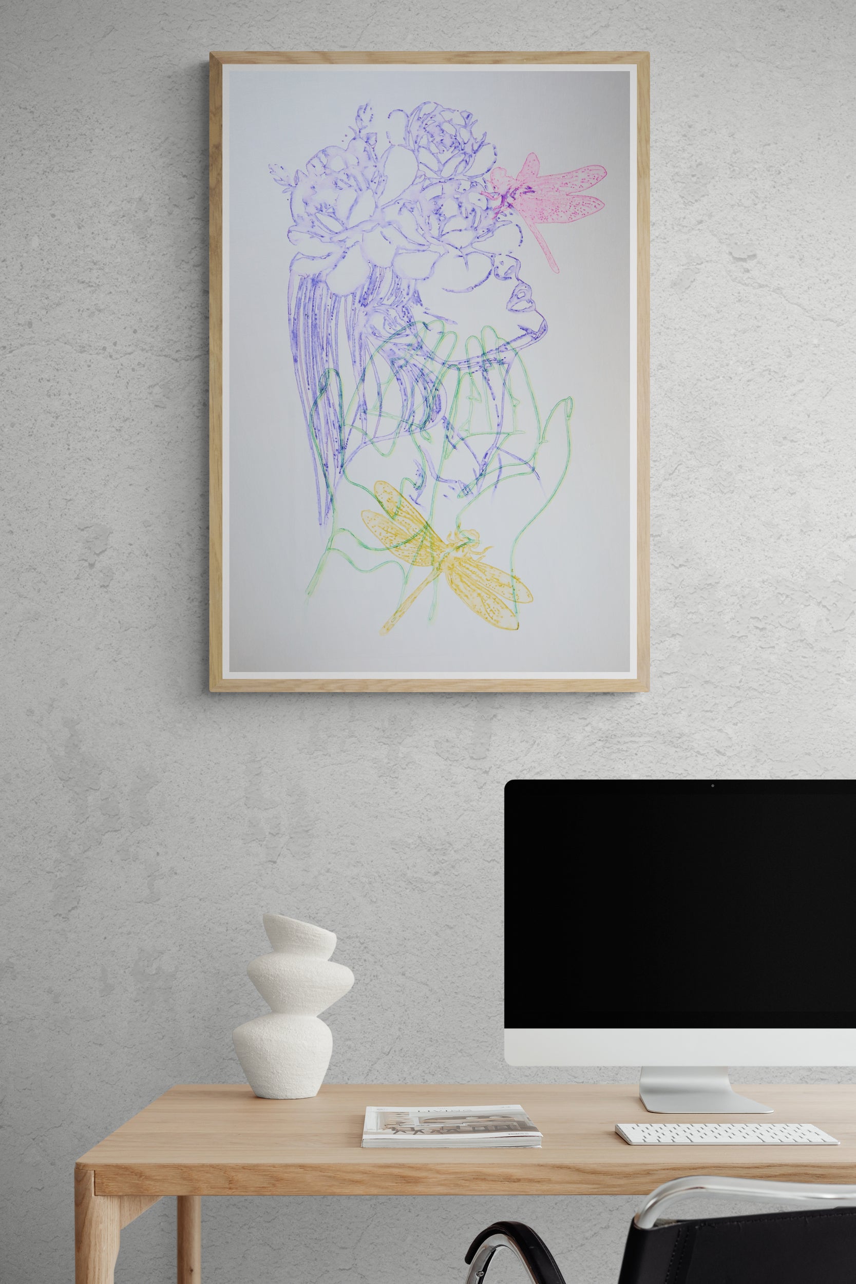 Œuvre de la collection Métamorphe encadrée, aquarelle sur papier, motif de mains, de libellules et d’un visage recouvert de fleurs, présentée en intérieur.