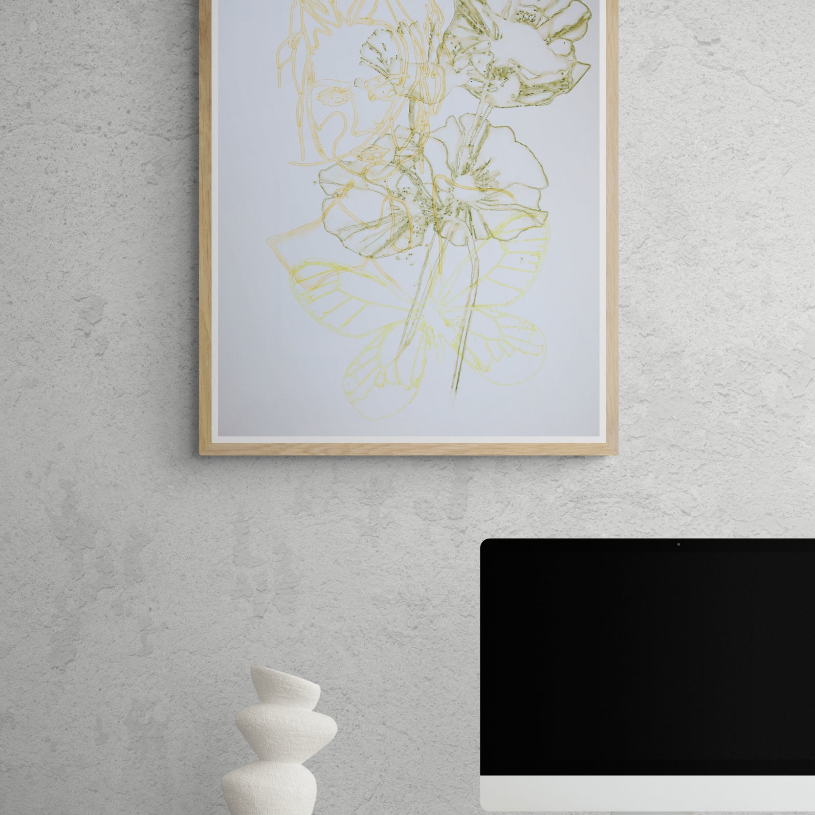 Œuvre de la collection Métamorphe encadrée, aquarelle sur papier, motif de visage, de fleur et de papillon, aux teintes jaune, vert et orange, présentée en intérieur.