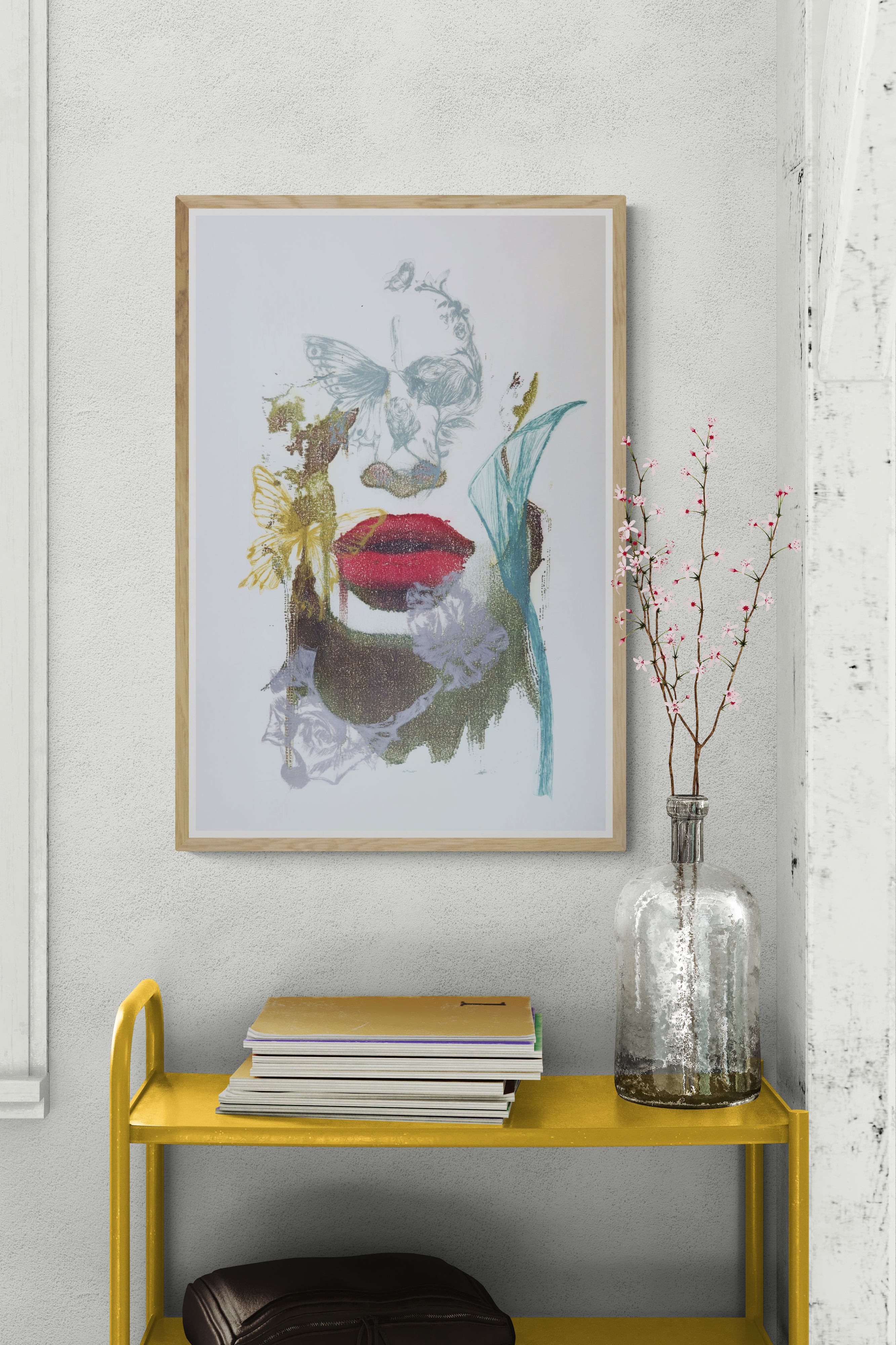 Œuvre de la collection Spiritus encadrée, gravure et image imprimée sur papier, visage fondu avec d’autres éléments, bouche rouge et papillon, présentée en intérieur.
