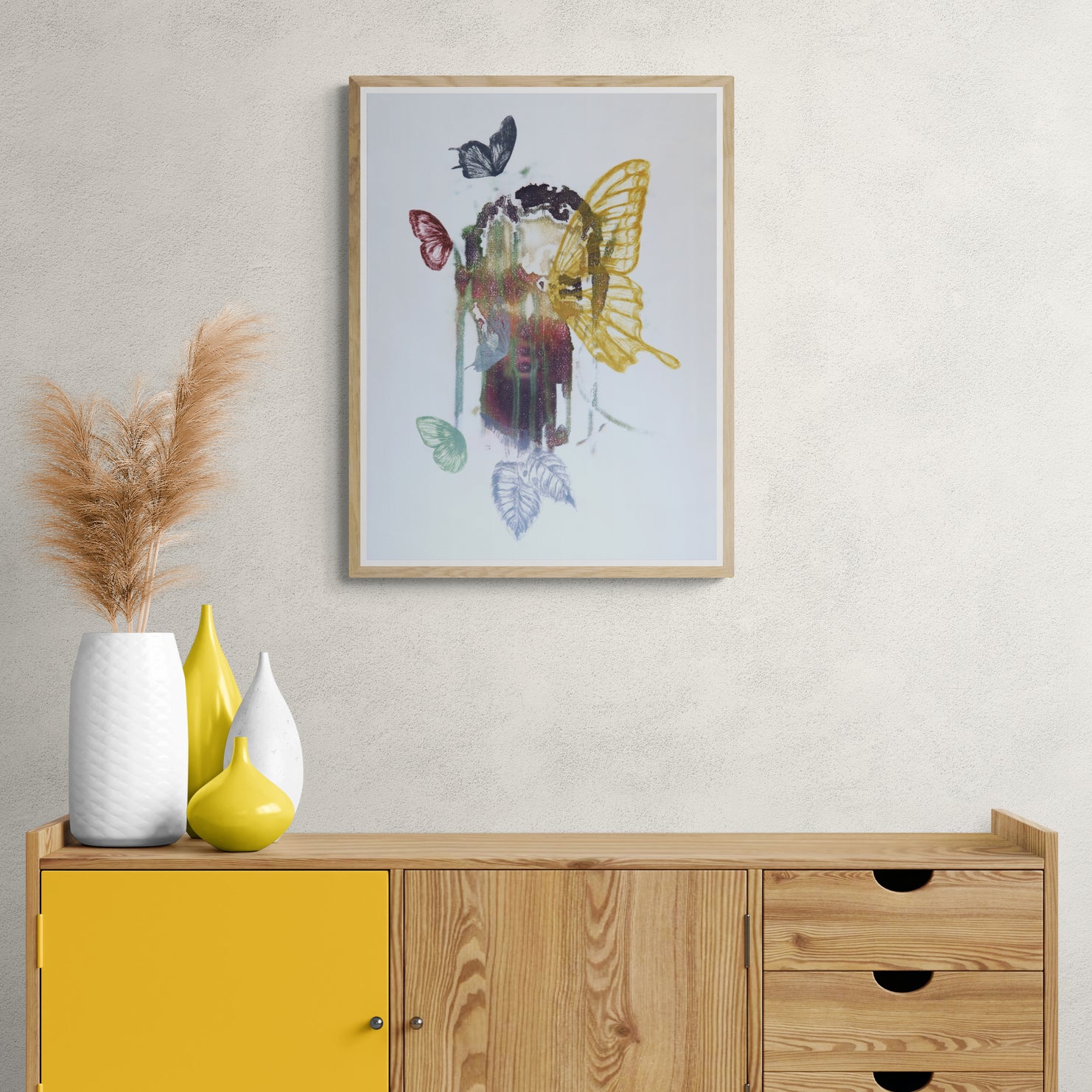 Œuvre encadrée de la collection Spiritus, gravure et image imprimée sur papier, visage intégré dans une composition avec papillons et éléments botaniques, présentée en intérieur.