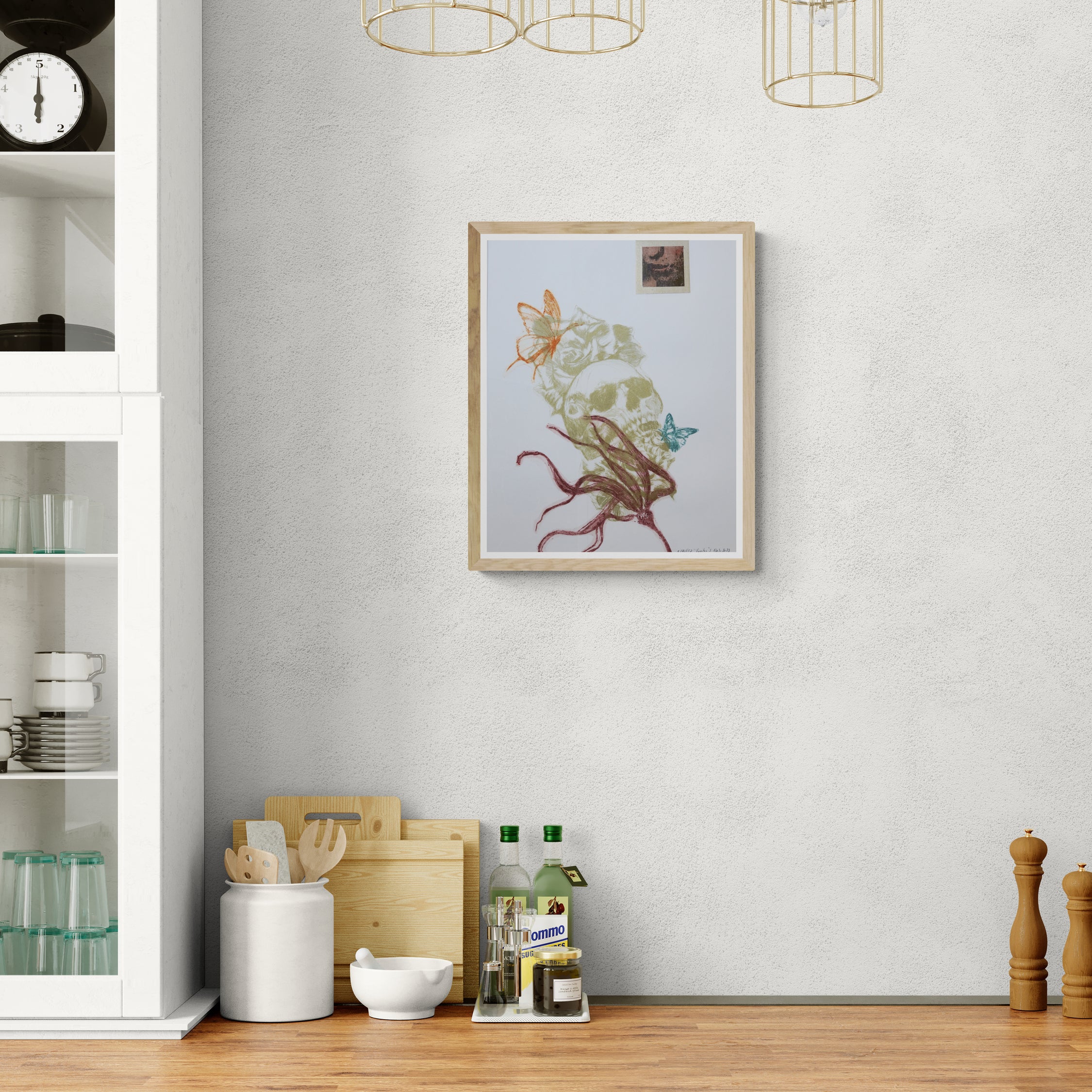 Œuvre encadrée de la collection Vanitas, gravure sur papier, crâne, fleurs et papillon, composition mouvementée, présentée en intérieur.